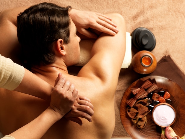 Masseur doing massage of backbone on man body in the spa salon. Beauty treatment concept.