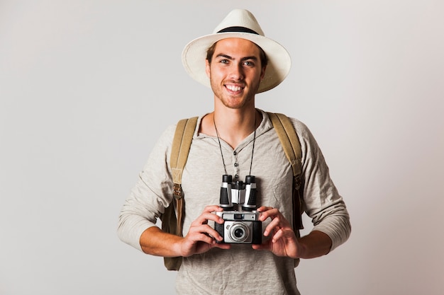 Smiling hipster style tourist with camera