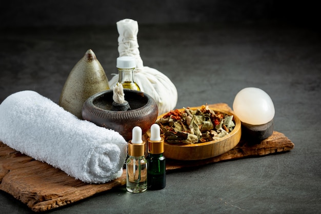 Herbal compress and herbal spa treatment equipments put on dark floor Free Photo