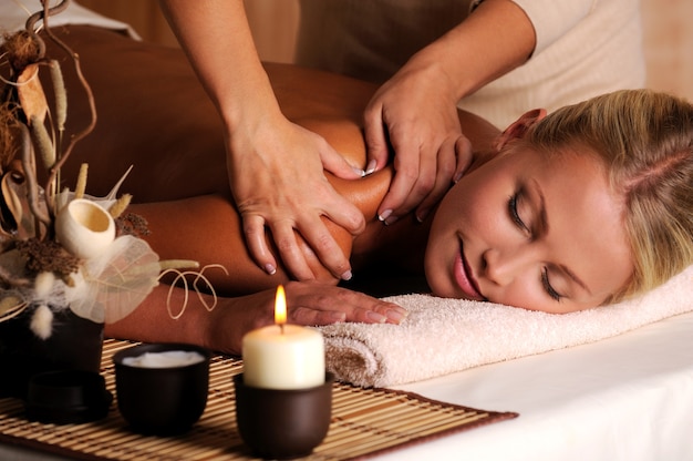 Free photo masseur doing massage on female shoulder in the beauty salon