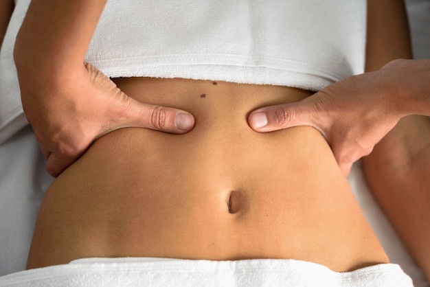 Free photo hands massaging female abdomen.therapist applying pressure on belly.