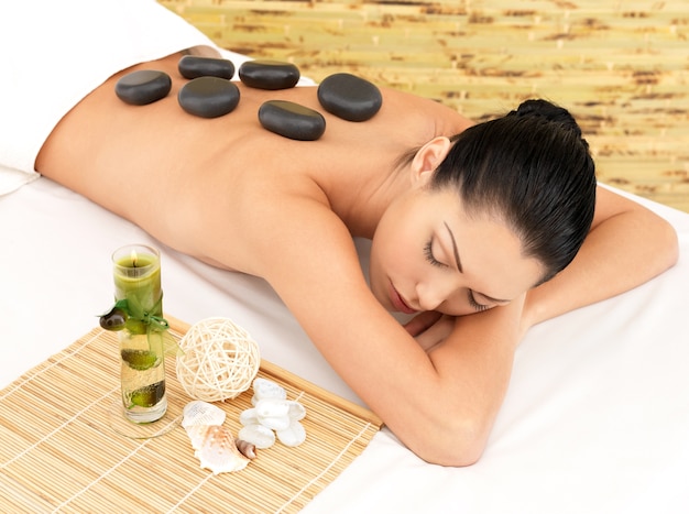 Free photo stone massage for young woman at beauty spa salon. recreation therapy.