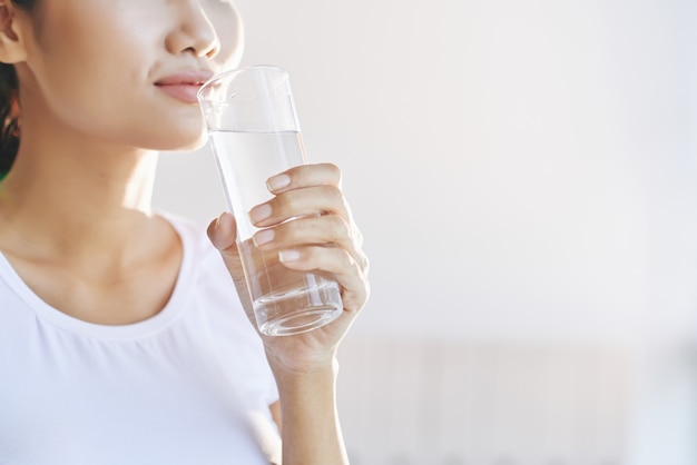Free photo unrecognizable woman carrying glass of water to mouth