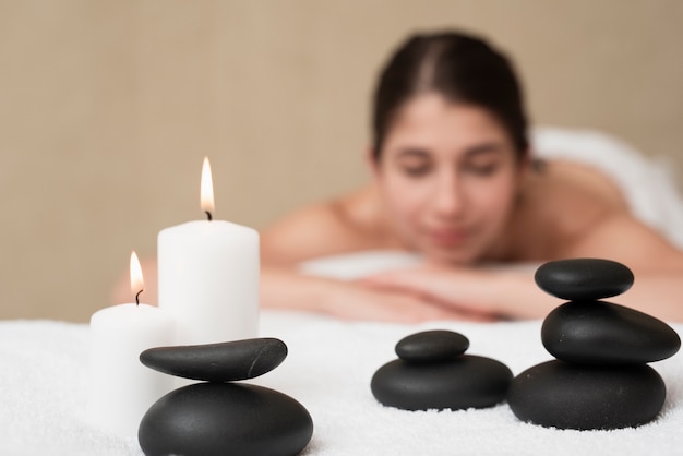 Free photo candles and spa rocks with woman at spa
