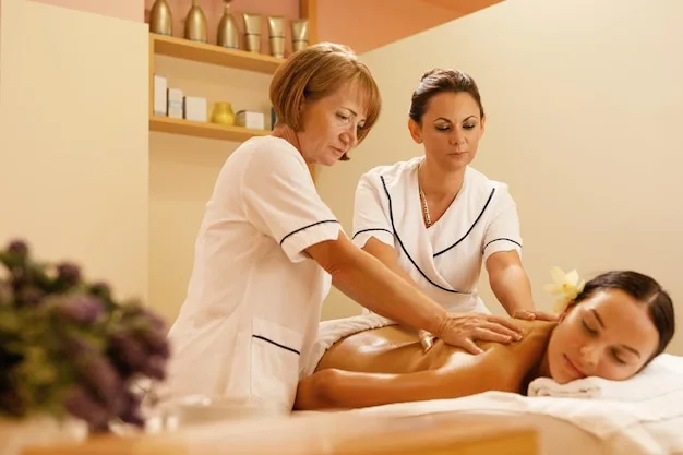 Free photo serene woman getting back massage by two therapists during spa treatment