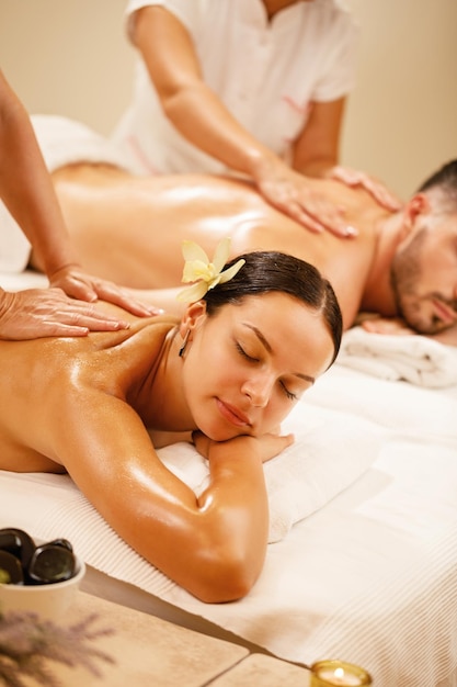 Young couple relaxing during back massage at health spa Focus is on young woman
